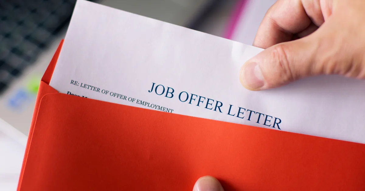 A signed job offer letter next to a set of house keys